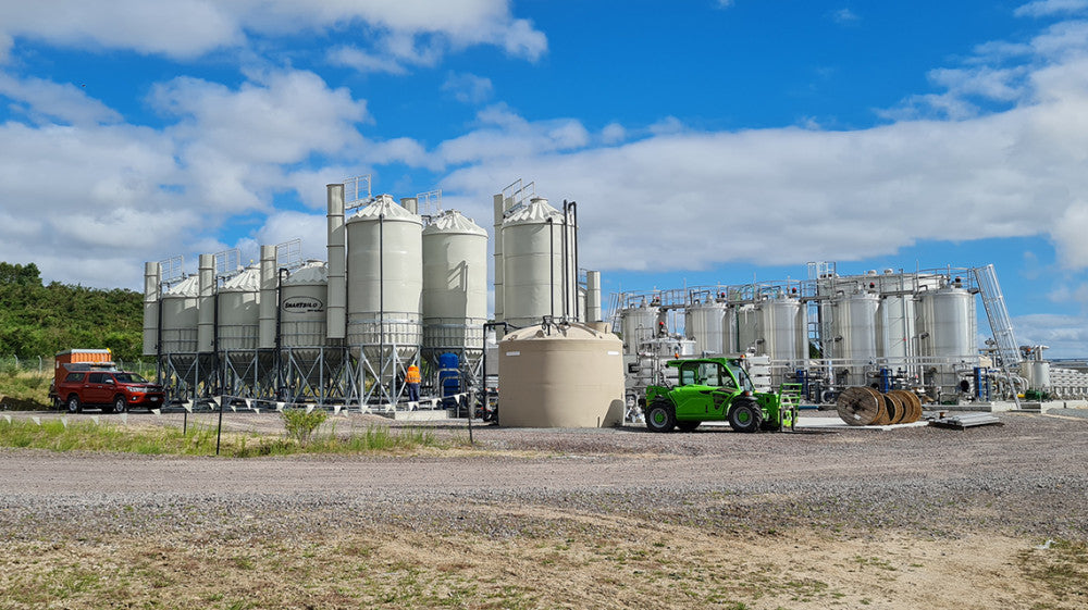 A Promax industrial tank installed among silos and processing equipment at a New Zealand industrial plant